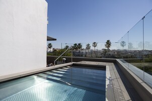 Una piscina al aire libre, sillones reclinables de piscina