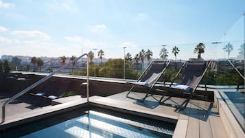 Una piscina al aire libre, sillones reclinables de piscina