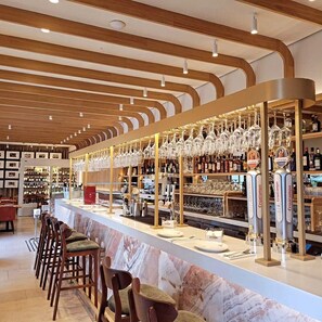 A bar area with wooden ceiling, bar stools, and shelves stocked with bottles and glasses. - Hotel Kivir Adults Recommended, Historic City Center (Seville)