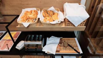 Een buffet met brood, gebak en een broodrooster.