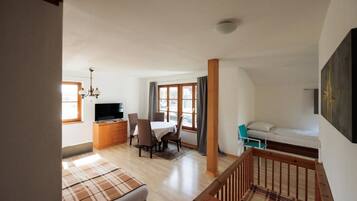 Een kamer met een bed, een bureau met stoel, een televisie en een raam.