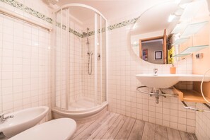 Une salle de bain avec une douche à parois de verre, un lavabo et des toilettes.