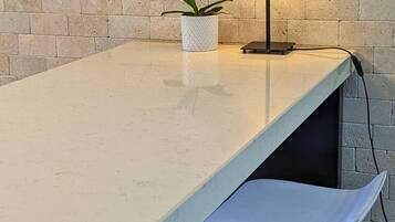 Contemporary room with a light-colored countertop, a vase with white flowers, and a floor lamp.