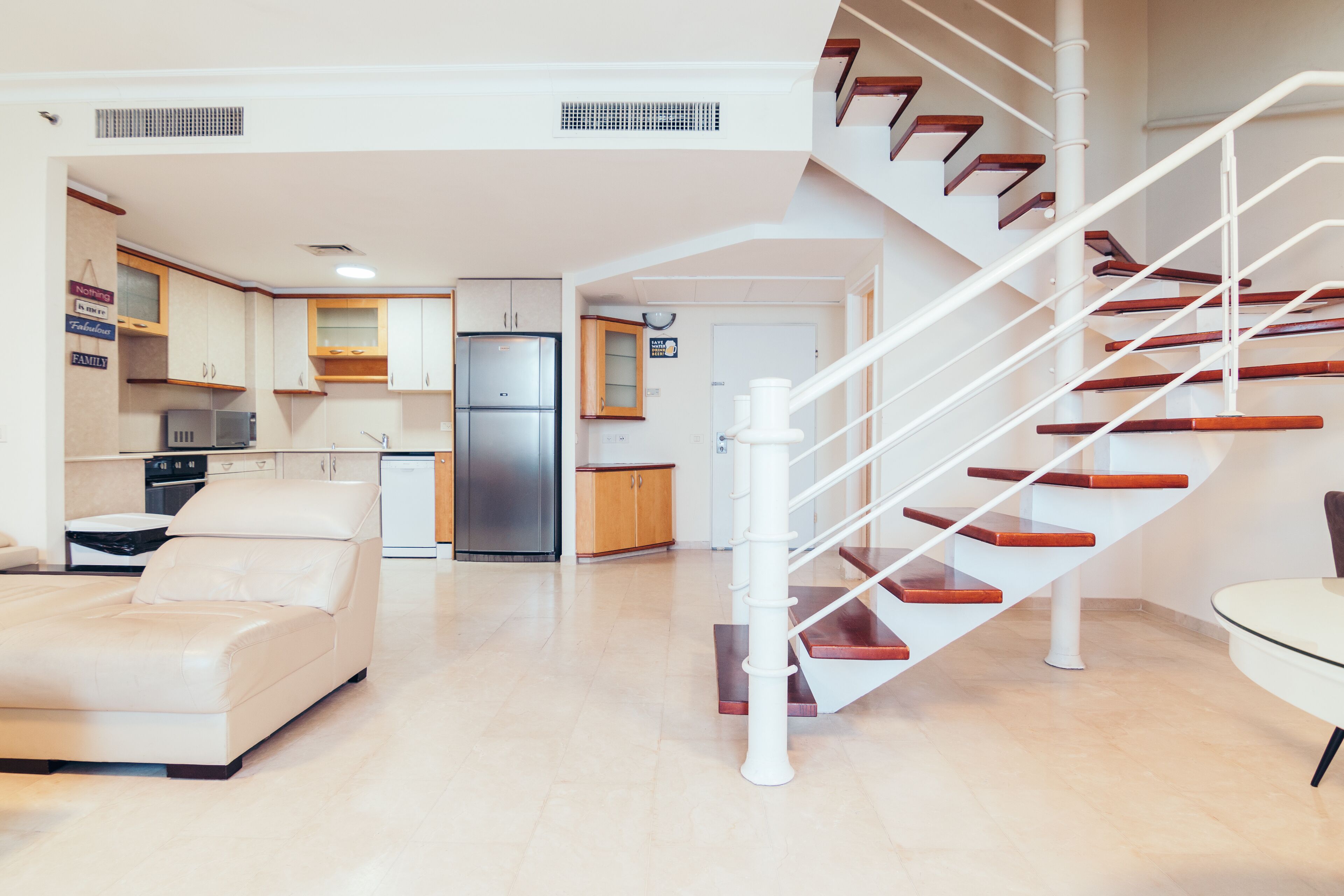 Un salon moderne avec un canapé, une table à manger et un escalier en colimaçon.
