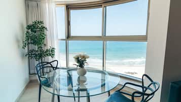 Suite panorámica, 2 habitaciones, vista a la playa | Área de sala de estar | Televisión