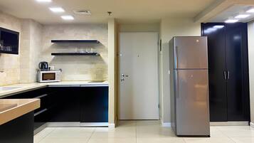 A modern kitchen with a microwave, toaster, and black cabinets.