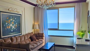 A living room with a sofa, a coffee table, and a view of the sea. - Almog Beach (Haifa)