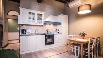 Apartamento, 2 quartos | Cozinha privada | Geladeira grande, cooktop, talheres/pratos/utensílios de cozinha