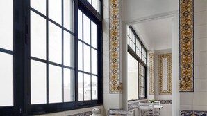 A room with large windows, white furniture, and decorative tile borders. - 1924 (Lisbon)