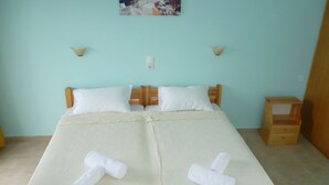 Un lit avec une couvre-lit à rayures, deux oreillers et deux serviettes enroulées.