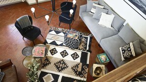 A living room with a grey sofa, black chairs, a patterned rug, and a modern floor lamp. - Best Location Rooftop and Pitti Palace View (Florence)