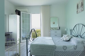 A bedroom with a bed, a dresser, a chair, and a wardrobe. - Bed & Breakfast da Beatrice (Sirmione)