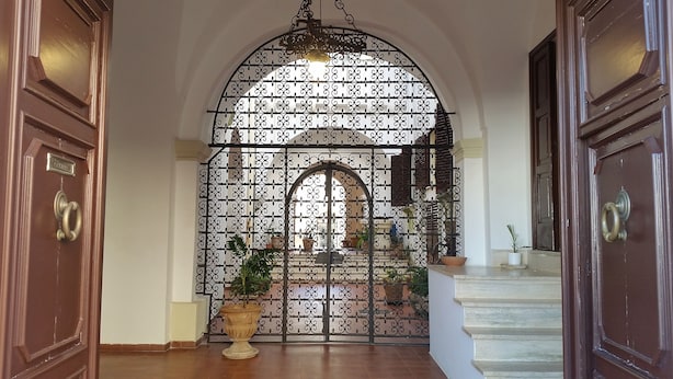 A grand entrance with an ornate metal gate, a staircase, and potted plants. - B&B Casa Resci (Tricase)