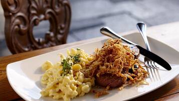A plate of food with macaroni, beef, and fried onions.