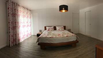 A bedroom with a wooden bed, a nightstand, a lamp, and a ceiling light.