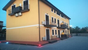 A two-story building with balconies and air conditioning units.