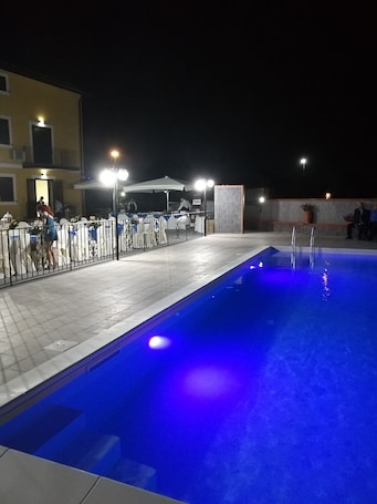 Una piscina al aire libre de temporada, sombrillas
