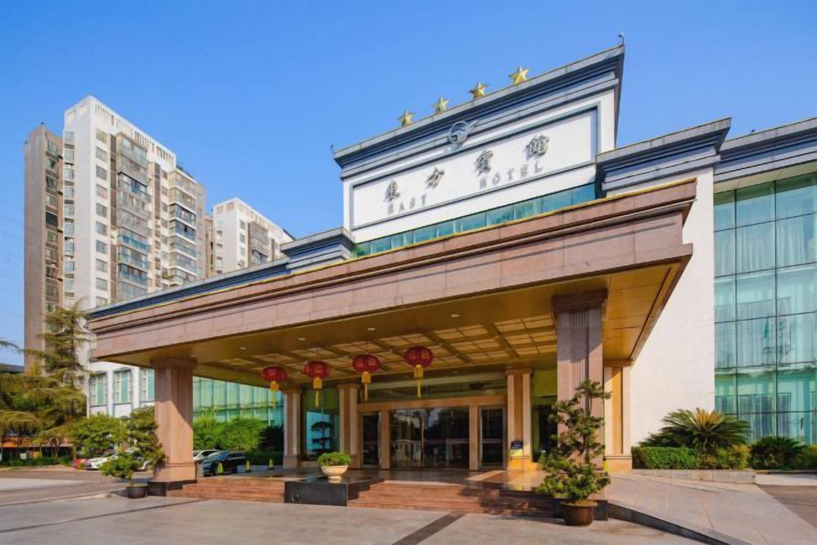 A hotel with a modern facade, large windows, and a covered entrance area.