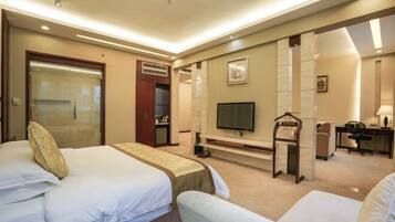 A hotel room with two beds, a TV, a desk, and a wardrobe.