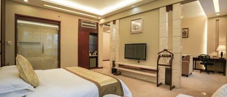 Habitación de hotel con dos camas, televisión, escritorio y armario.