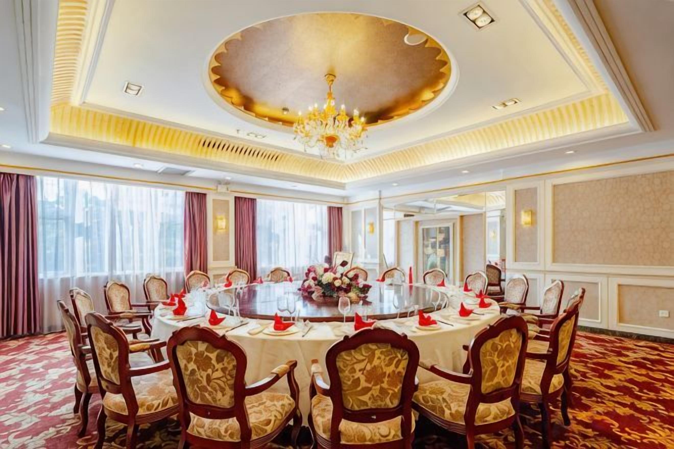A conference room with a round table, chairs, and a chandelier.