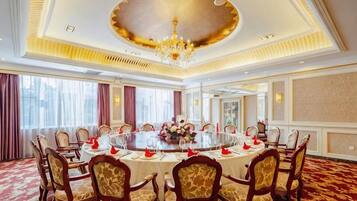 A conference room with a round table, chairs, and a chandelier.