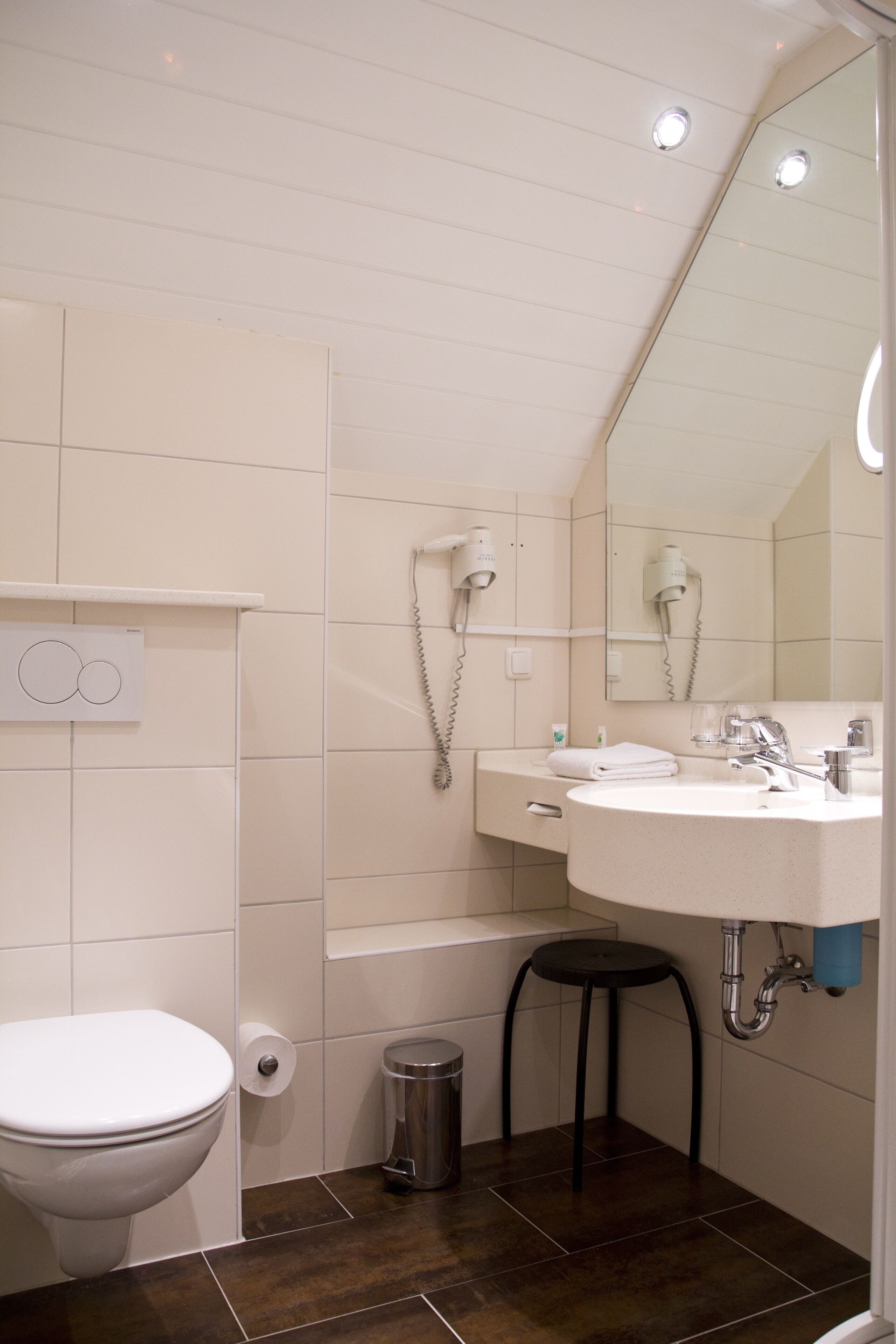 Un baño con inodoro, lavamanos y espejo.
