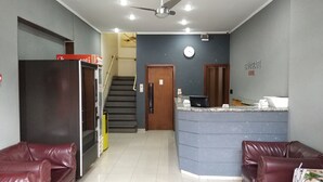 A hotel lobby with a reception desk, a staircase, and leather seating areas. - Hotel Itamarati (São José do Rio Preto)