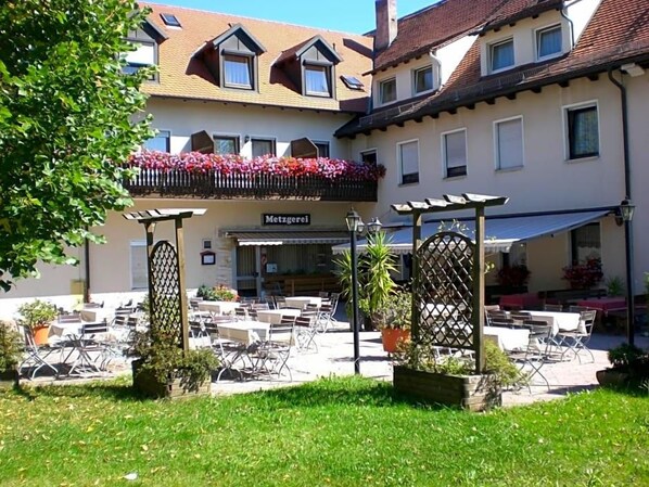 A courtyard with outdoor seating, a covered area, and a building labeled 'Metzgerei'.