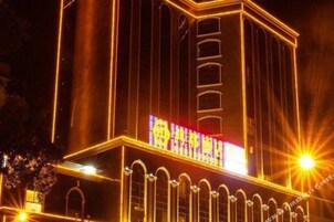 Un edificio con señalización iluminada y ventanas arqueadas.