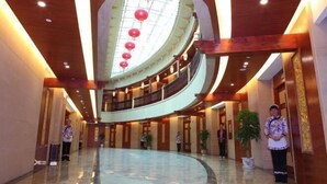 A spacious lobby with a curved ceiling, a central atrium, and red lanterns. - Hongdu Hotel (Xingning)
