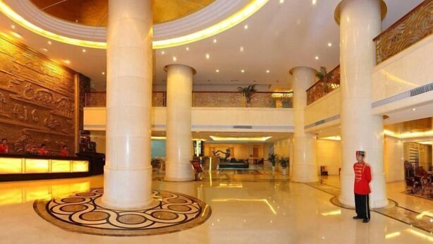 A spacious lobby with high ceilings, large columns, and a central reception area. - Hongdu Hotel (Xingning)