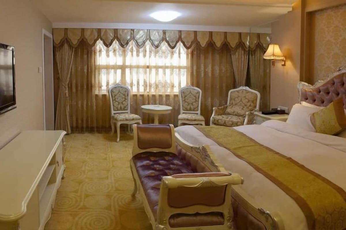 Ein Hotelzimmer mit einem Bett, einem Schlafsofa, zwei Sesseln, einem kleinen Tisch und einem Fernseher.