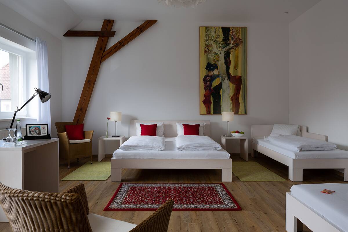 Une chambre moderne avec un grand lit, deux tables de chevet, un bureau et une chaise.