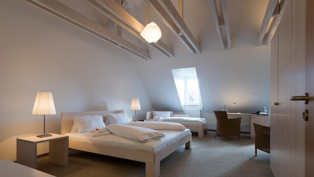Una camera da letto moderna con due letti, una scrivania e una sedia.