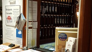Ein Empfangsschalter mit einer Holzeinlage, einem Glasständer und einem Schild mit der Aufschrift 'RECEPTION'.