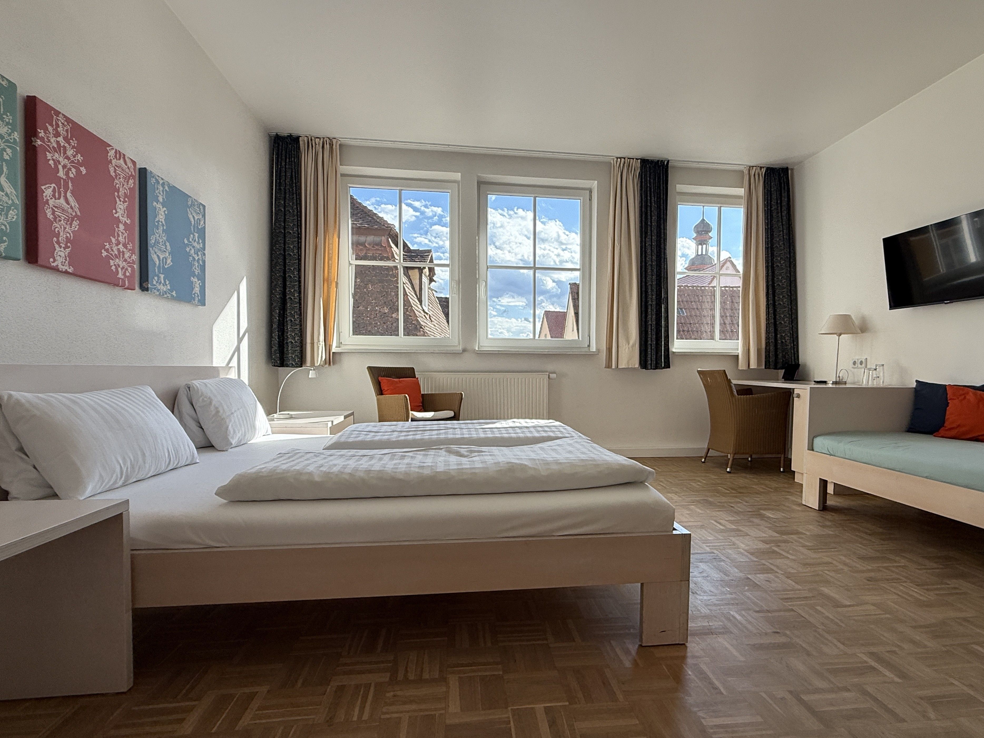 Un dormitorio moderno con cama, escritorio y televisor.