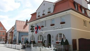 A building with a sign reading "Storch" and multiple flags, including the Canadian flag, indicating a possible location in Canada.