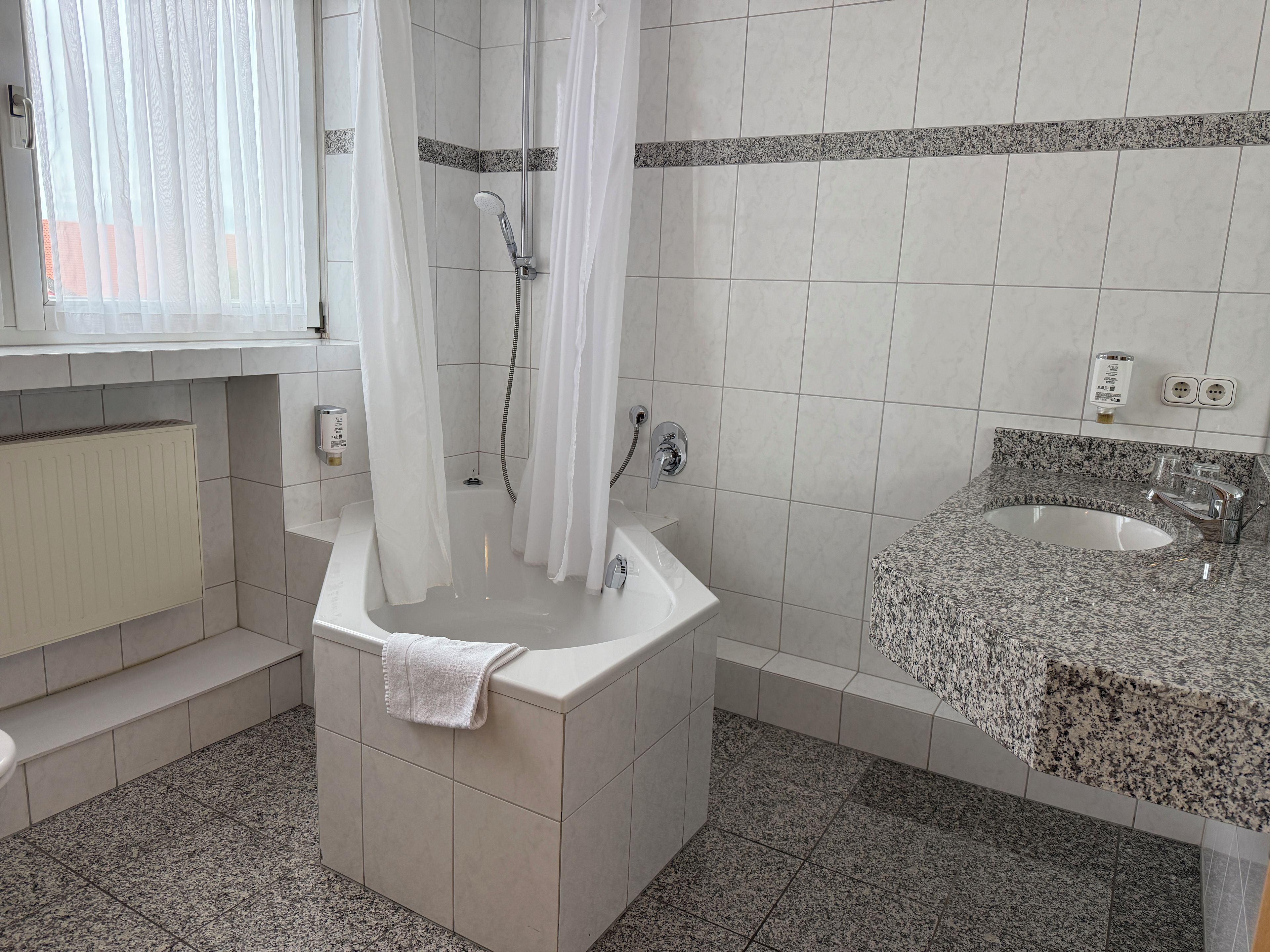 A bathroom with a shower, a sink, and a toilet.
