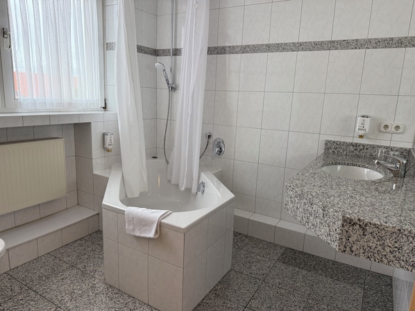 A bathroom with a shower, a sink, and a toilet.
