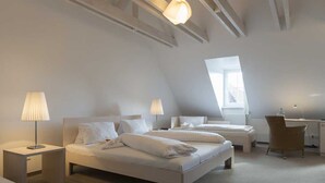 Ein modernes Schlafzimmer mit zwei Betten, einem Schreibtisch und einem Stuhl.