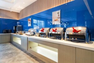 Montaje tipo buffet con varias estaciones de autoservicio, un dispensador de agua y una máquina de café.