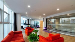 Ein modernes Interieur mit roten Sofas, einem weißen Tisch und einem Topf mit Pflanze.