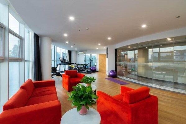A modern interior with red sofas, a white table, and a potted plant.