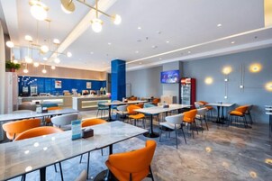 A modern restaurant with a bar area, seating arrangements, and a television screen.