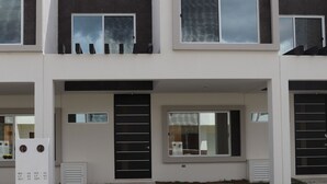 A modern two-story house with a flat roof, large windows, and a front door. - Casa Vacacional Brothers House Economica (Playa del Carmen)