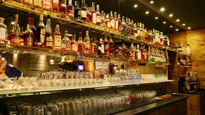 A bar with multiple shelves of liquor bottles and a variety of glasses. - Hotel Filipinum (Jablonne nad Orlici)