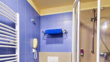 Ein Badezimmer mit Toilette, Dusche, Handtuchhalter und einem Fön.