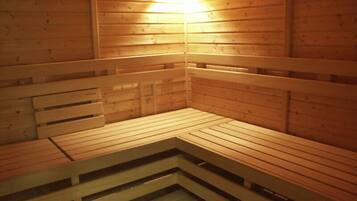 Uma sauna com bancos de madeira e um acessório de iluminação na parede.