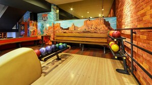 A bowling alley with a mural of Route 66 and a wooden bench. - Hotel Filipinum (Jablonne nad Orlici)